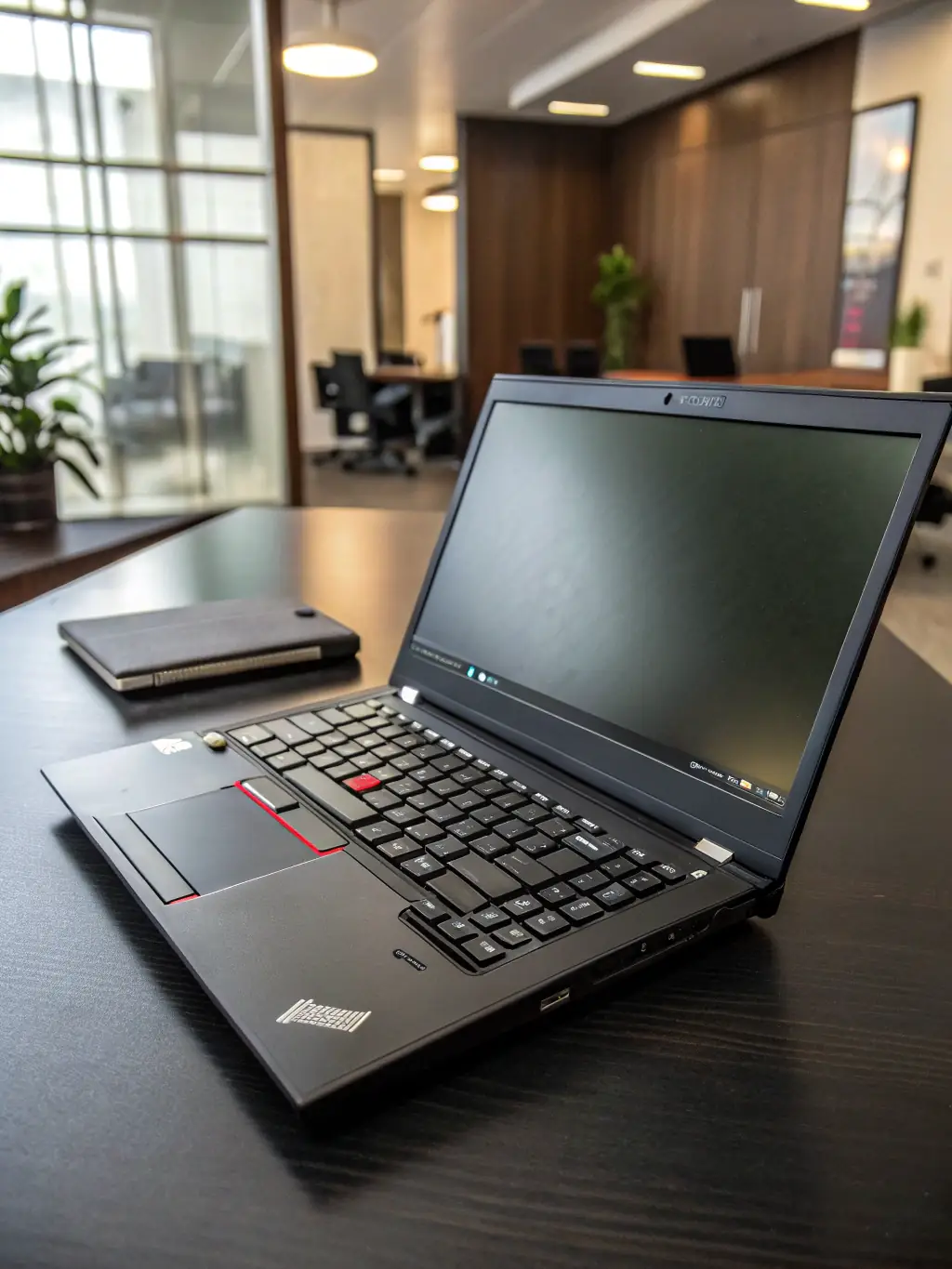 A close-up shot of a Lenovo ThinkPad's hinge, showcasing its robust metal construction and durability, set against a blurred background of a rural Indian landscape.